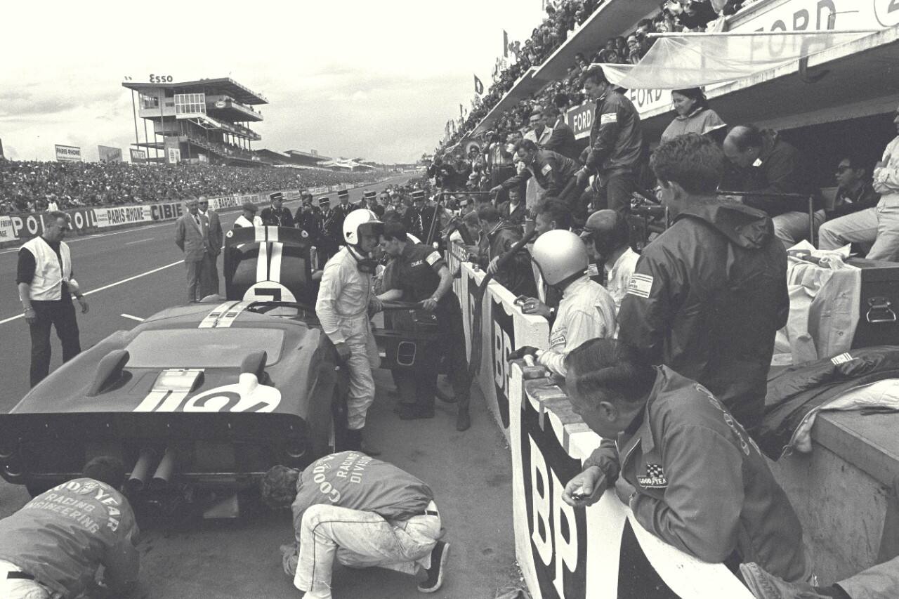 A driver at a pit stop faces the crowd.